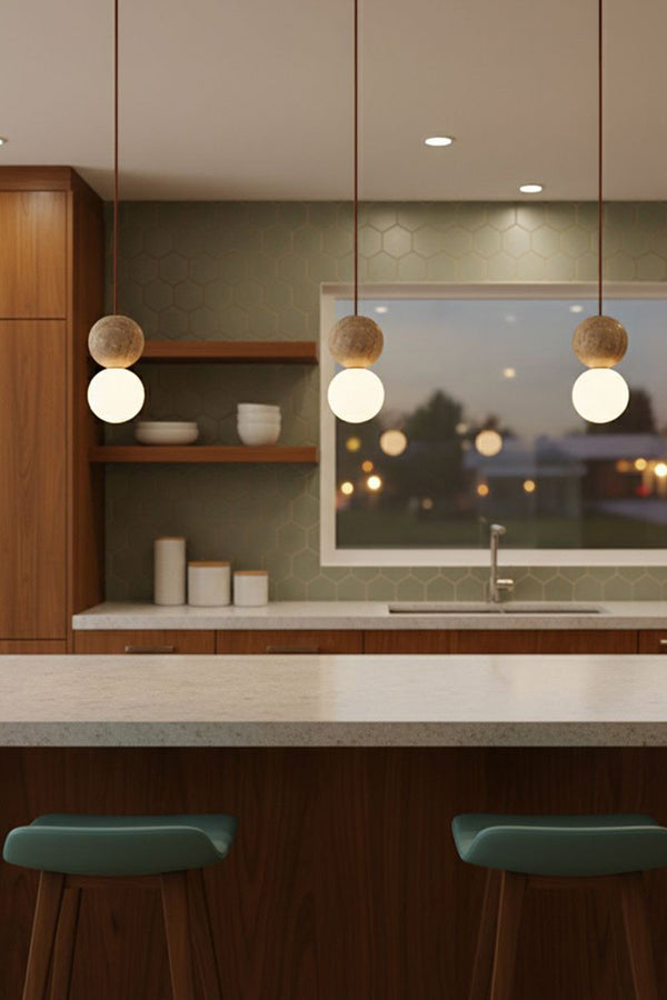 Modern travertine and glass pendant lights | Yellow Travertine, Glass | 3-light cluster over a kitchen bar with green stools | Samu Lamp