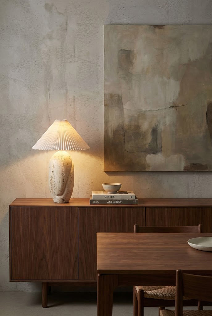 Modern organic stone table lamp | Travertine, Fabric | On a dark wood sideboard with abstract wall art | Samu Lamp