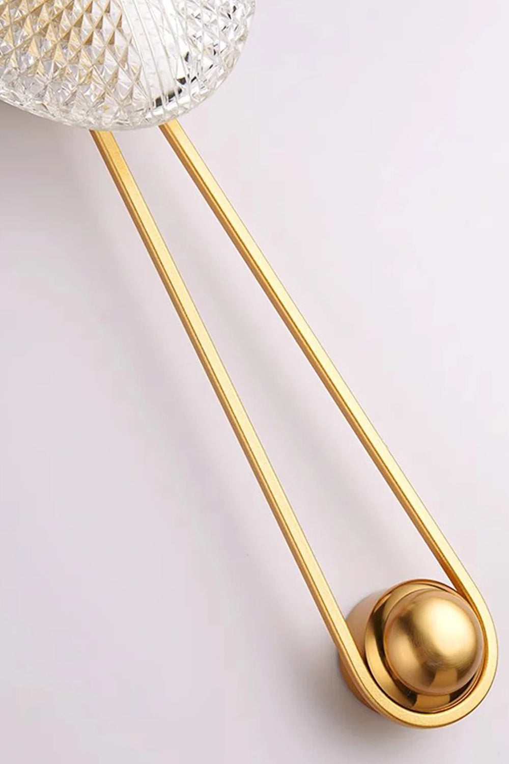 Vara Aura Woven Acrylic Wall Lamp | Woven Acrylic, Brass | Close-up detailed view of the elongated golden brass loop frame and round mounting fixture | Samu Lamp