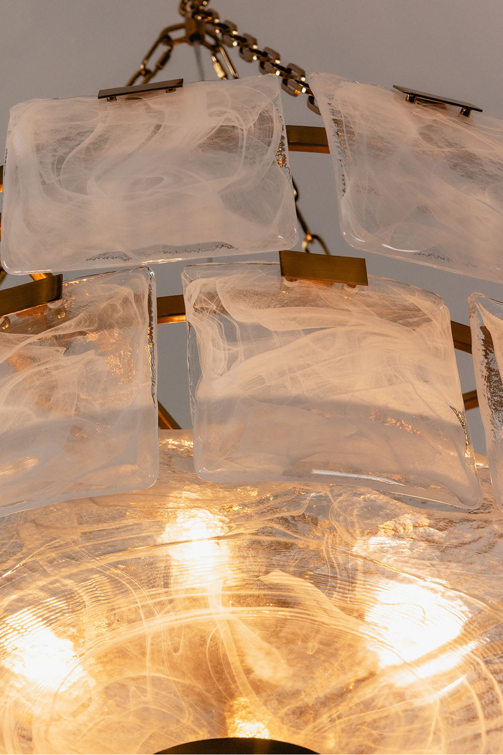 Close-up view of Verel Stepped Glass Drum Chandelier showcasing its elegant glass design and warm lighting.