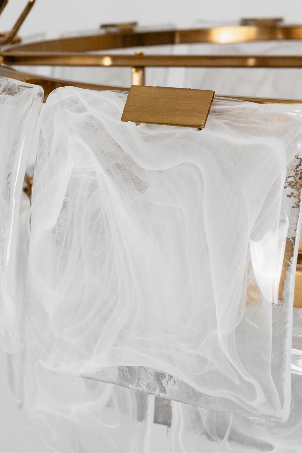 Close-up view of the Verel Stepped Glass Drum Chandelier showcasing its elegant glass detail and brass accents.
