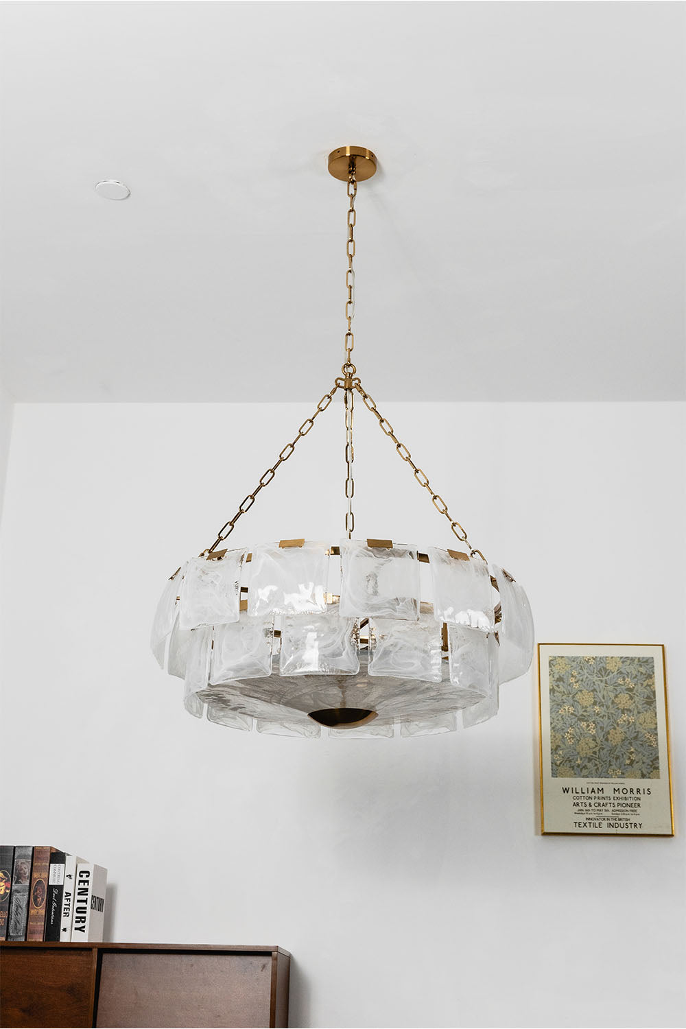 Verel Stepped Glass Drum Chandelier hanging from a gold chain, enhancing the elegance of modern interior decor.