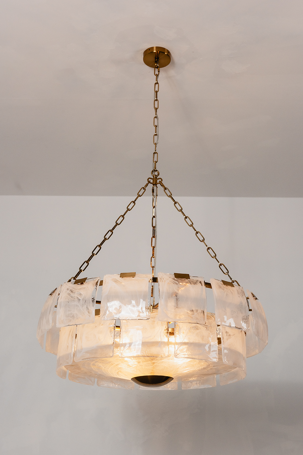 Verel Stepped Glass Drum Chandelier hanging from a gold chain, featuring a unique stepped glass design.