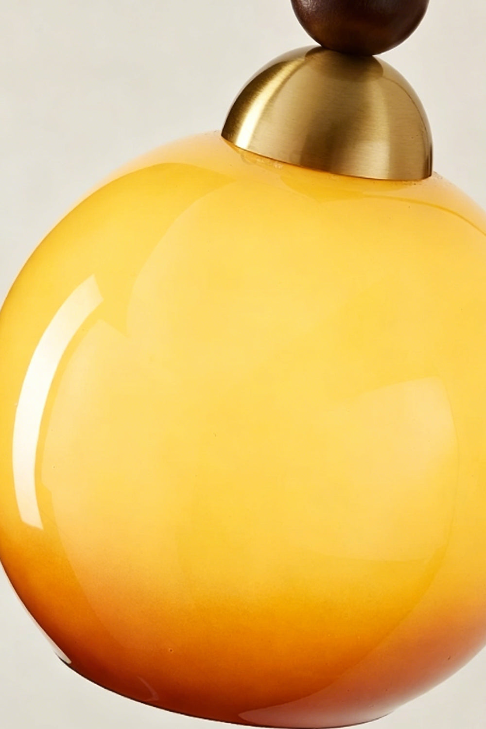Vesper Caramel Gradient Wall Lamp | Glass, Metal, Wood | Macro shot highlighting the smooth glossy surface and warm orange-to-yellow color gradient of the glass shade | Detail shot | Samu Lamp