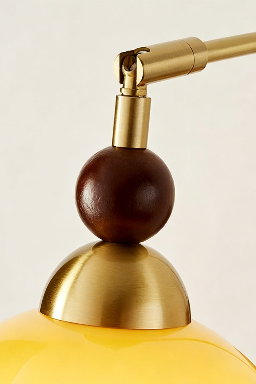Vesper Caramel Gradient Wall Lamp | Glass, Metal, Wood | Detailed close-up showing the spherical dark wood bead accent and polished gold brass socket cap assembly | Detail shot | Samu Lamp