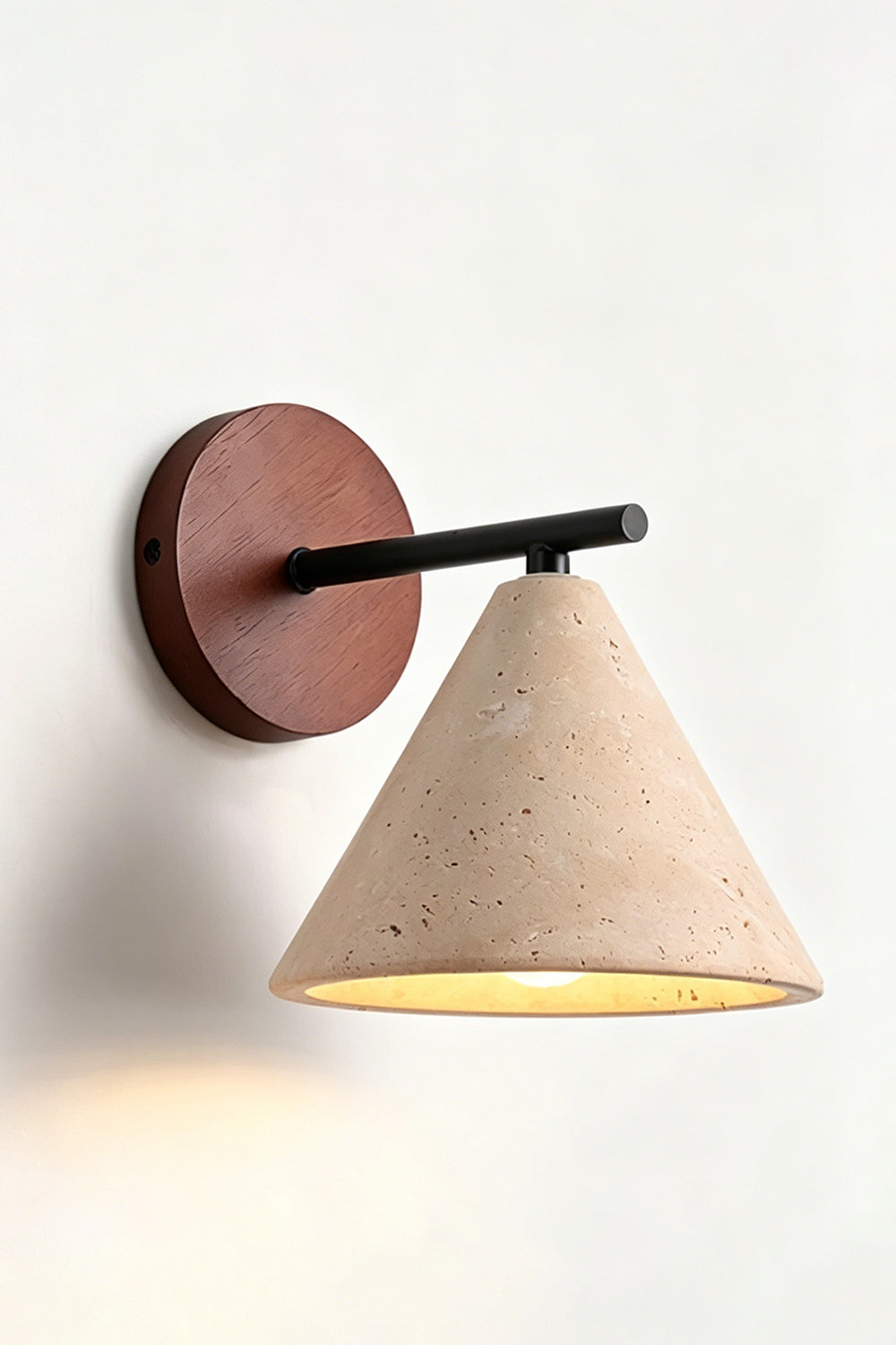 Vesper Cone Travertine Wall Light | Travertine, Wood | Side perspective of lit product on wall | Samu Lamp