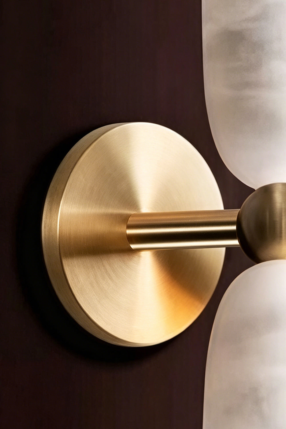Vesperal Axis Alabaster Wall Lamp | Alabaster, Metal | Close-up of the circular gold metal mounting plate and connecting arm | Detail shot | Samu Lamp