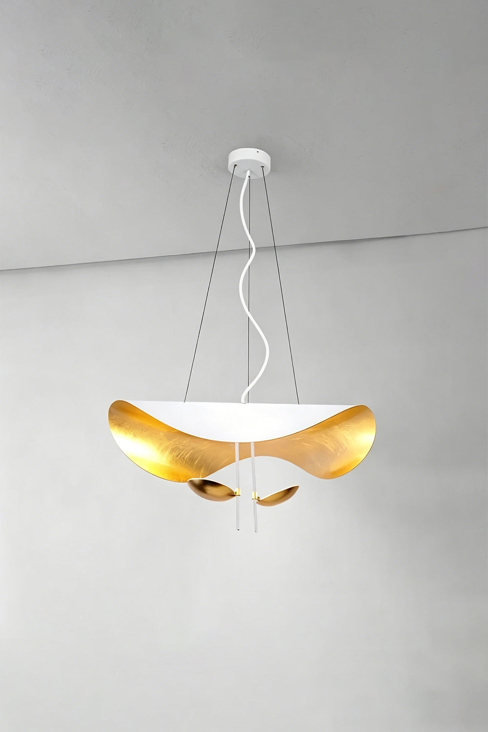 Voluta Horizon Metal Pendant Light | Metal | White and gold variant illuminated against a simple plain wall corner | Samu Lamp