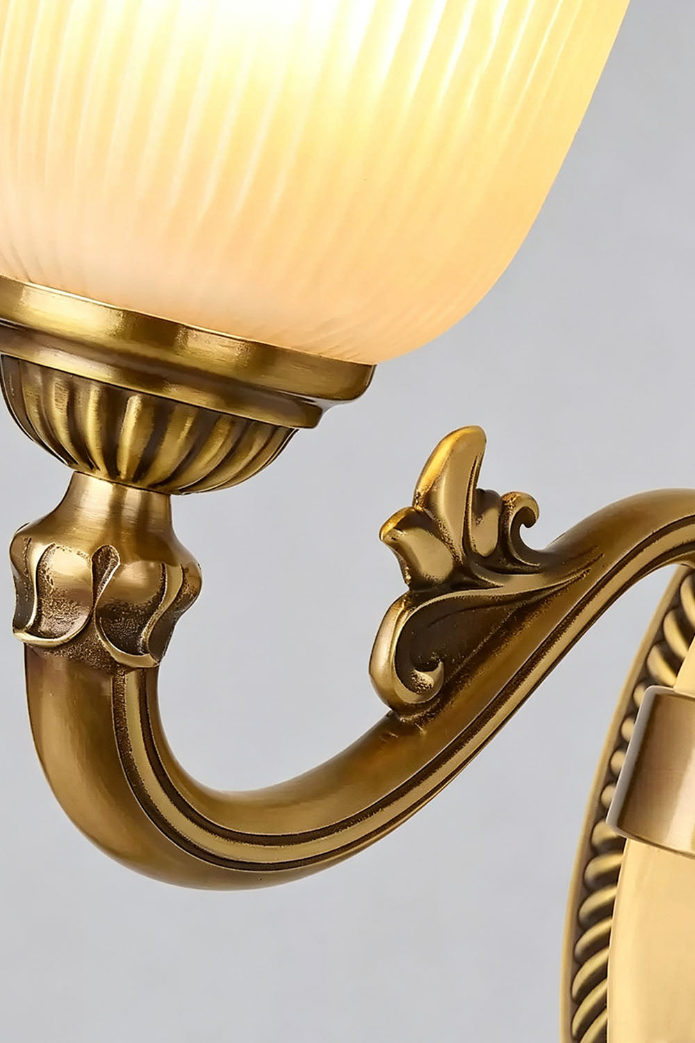 Close-up of the Whitlock Fluted Bell Brass Wall Lamp showcasing ornate details and elegant light fixture design.