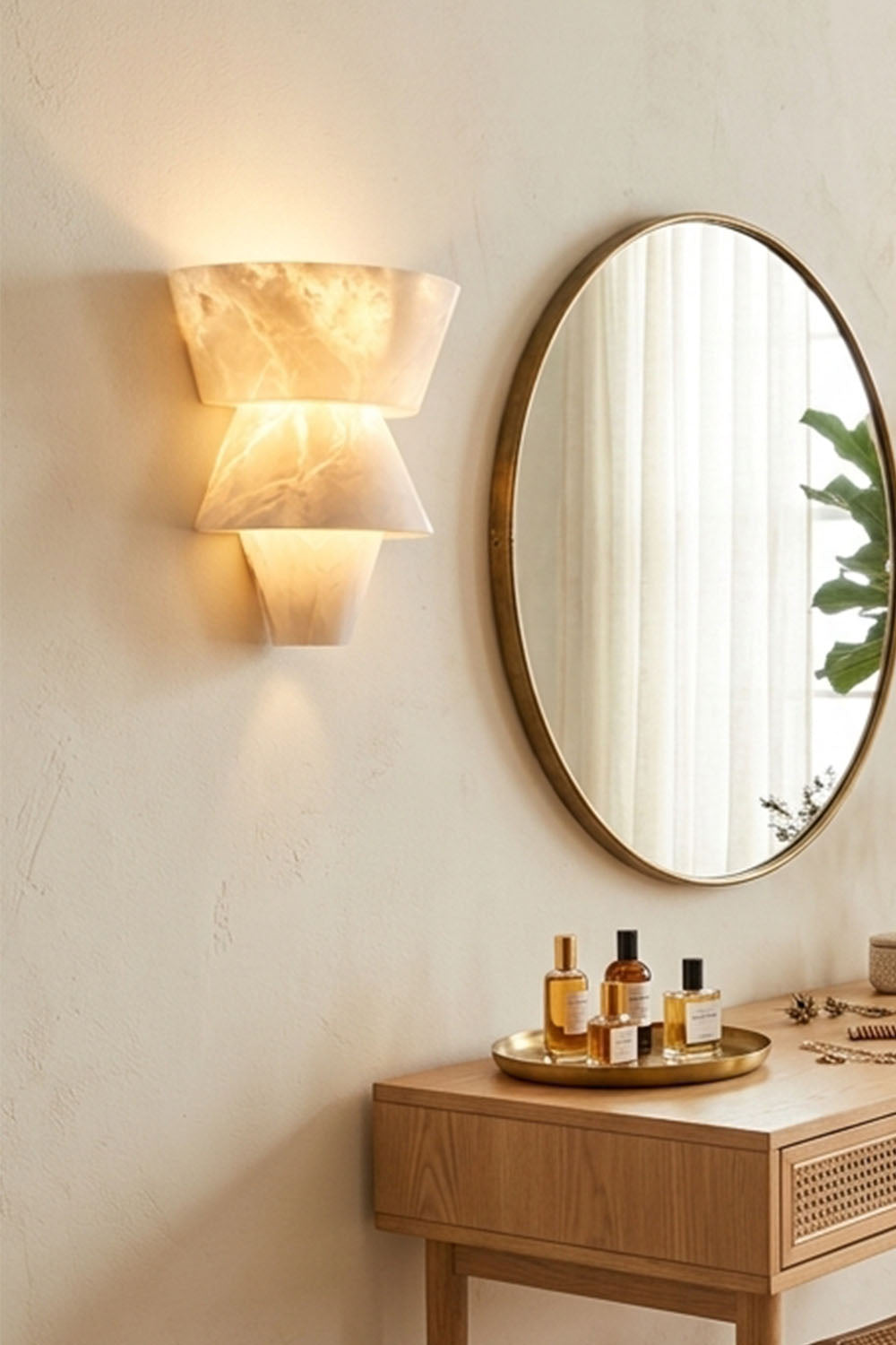 Wystan Twin Cone Alabaster Wall Lamp | Natural Alabaster and Metal | Close view of the wall lamp mounted near a round mirror above a wooden counter | Samu Lamp